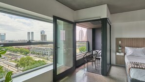 A modern bedroom with a large window, a balcony, and a city view. - Alma Rentals Huergo 475 (Buenos Aires)