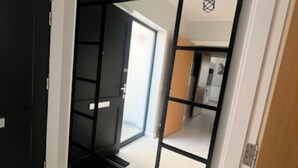 Une pièce dotée d’une porte-fenêtre coulissante qui donne sur un espace cuisine.