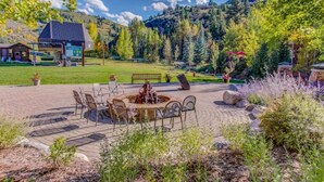 A patio area with a fire pit, outdoor seating, and a view of a mountain. - Arrowhead at Beaver Creek, Direct Ski Access & A/C (Edwards)