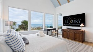 Ett sovrum med en stor säng, ett skrivbord och en tv som visar ”LYXIGA HYREOBJEKT PÅ HILTON HEAD”.