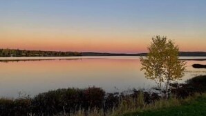 Ein ruhiger See bei Sonnenuntergang unter einem klaren Himmel.