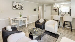 Una sala de estar moderna con comedor, cocina y baño.