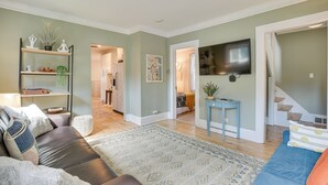 A living room with a sofa, a coffee table, and a TV mounted on the wall. - Classic Forest Park Foursquare < 1 Mi to Blue Line (Forest Park)