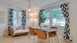 A dining area with a wooden table, four chairs, a sofa, and a lamp. - Classic Forest Park Foursquare < 1 Mi to Blue Line (Forest Park)