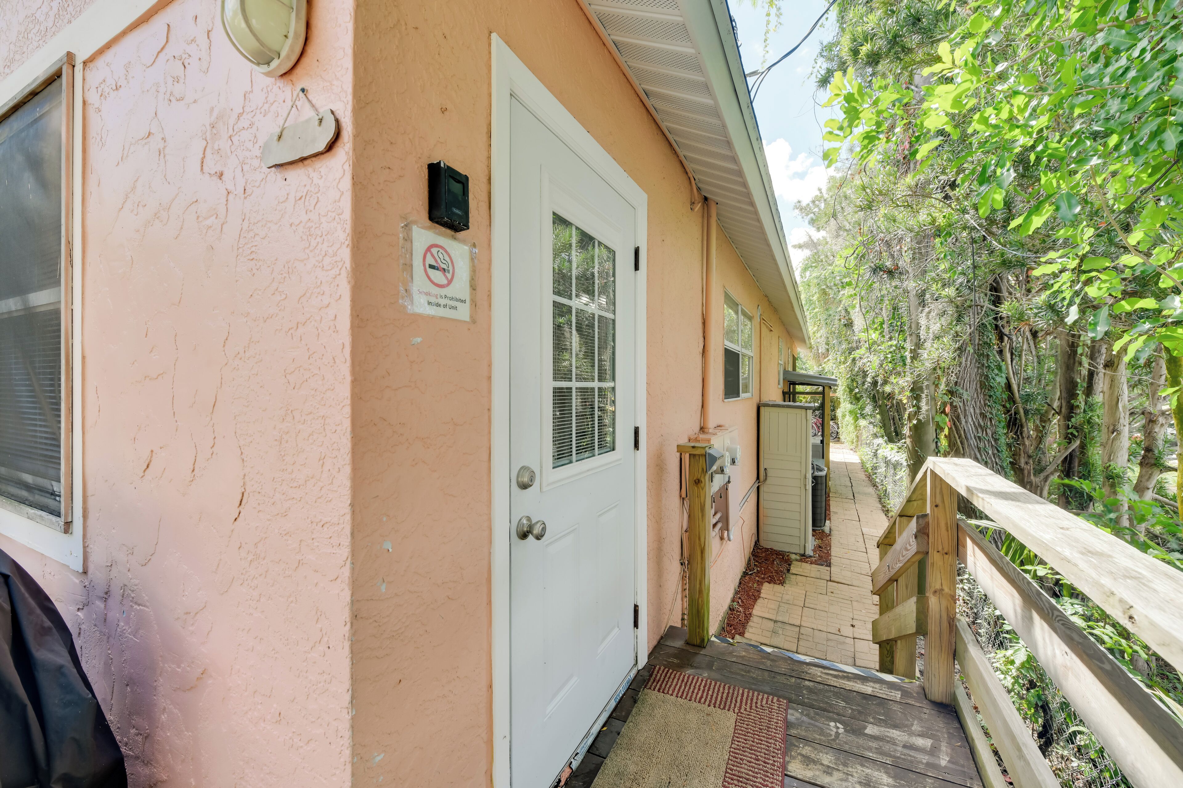 A building with a white door, a small porch, and a wooden railing.