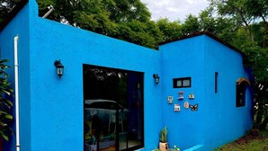 A blue house with a large glass door, a small porch, and decorative items on the wall. - Mexican style house in the heart of the magical town of San Andres Cholula. (San Andrés Cholula)