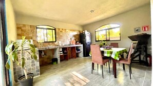 A spacious kitchen with a dining area, a refrigerator, and a potted plant. - Mexican style house in the heart of the magical town of San Andres Cholula. (San Andrés Cholula)