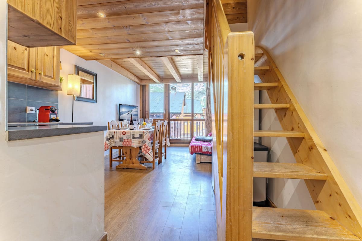 Un intérieur en bois comprenant une cuisine, un coin repas et un escalier.