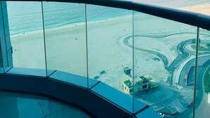 A view from a balcony overlooking a beach with a clear sky.