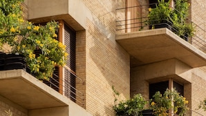 A multi-story building with balconies, some with plants. - Torrearena Design Hotel (Puerto Escondido)