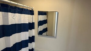 A bathroom with a white sink, a mirror, and a striped shower curtain. - 5 Min to Salem~Comfy King Beds (Beverly)