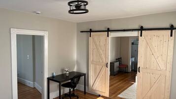 2 habitaciones, escritorio y tabla de planchar con plancha