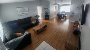 A living room with a sofa, coffee table, and a dining area with chairs and a table. - Tampa Travel Hub - TPA Airport tranquility (Tampa)