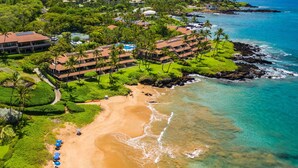 Une vue aérienne d’un complexe hôtelier comprenant plusieurs bâtiments, une plage et une vue dégagée sur l’océan.