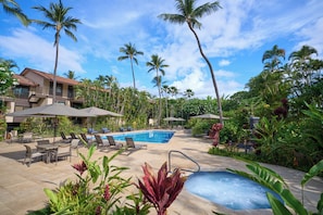 A pool area with lounge chairs, umbrellas, and a hot tub. - Makena Surf F208 | 180-Degree Ocean Views, Turtle Snorkeling & Resort Perks (Wailea)