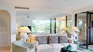 Una sala de estar moderna con un conjunto de sofá, sillones estampados y una escultura decorativa.