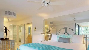 Un dormitorio moderno con una cama, un ventilador de techo, un espejo grande y una estatua decorativa.