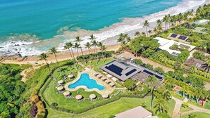Ein Luftbild eines Resorts mit Schwimmbad, Strandzugang und üppiger Bepflanzung.