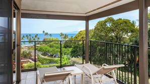 Un balcon avec vue sur l’océan et les palmiers.