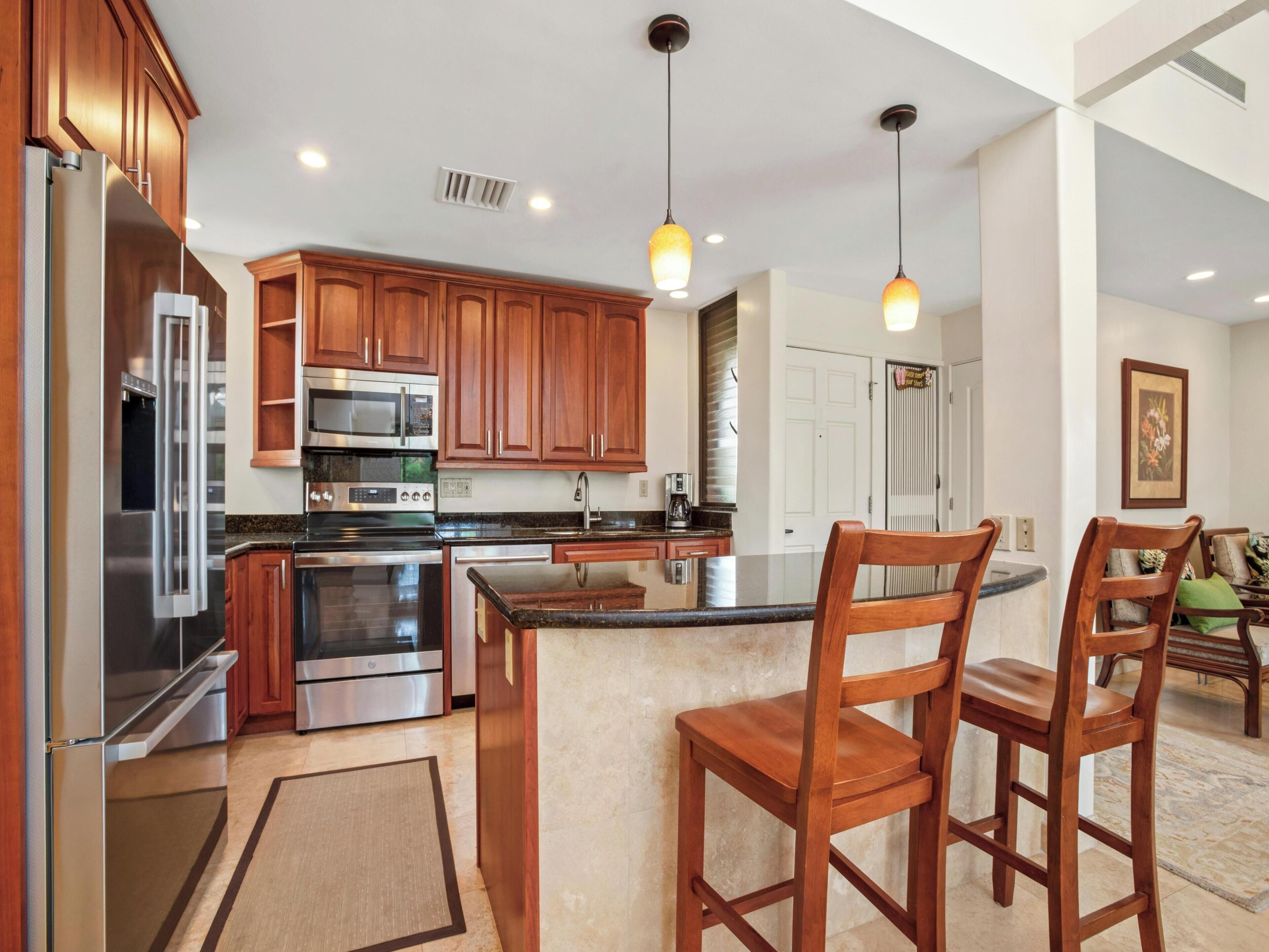 A modern kitchen with wooden cabinets, stainless steel appliances, and pendant lighting.