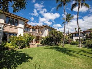 A two-story house with a patio, surrounded by lush greenery and palm trees. - Oceanfront with Private Plunge Pool (Wailea)