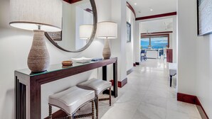 Un intérieur moderne avec une console, deux lampes, un miroir et un banc.