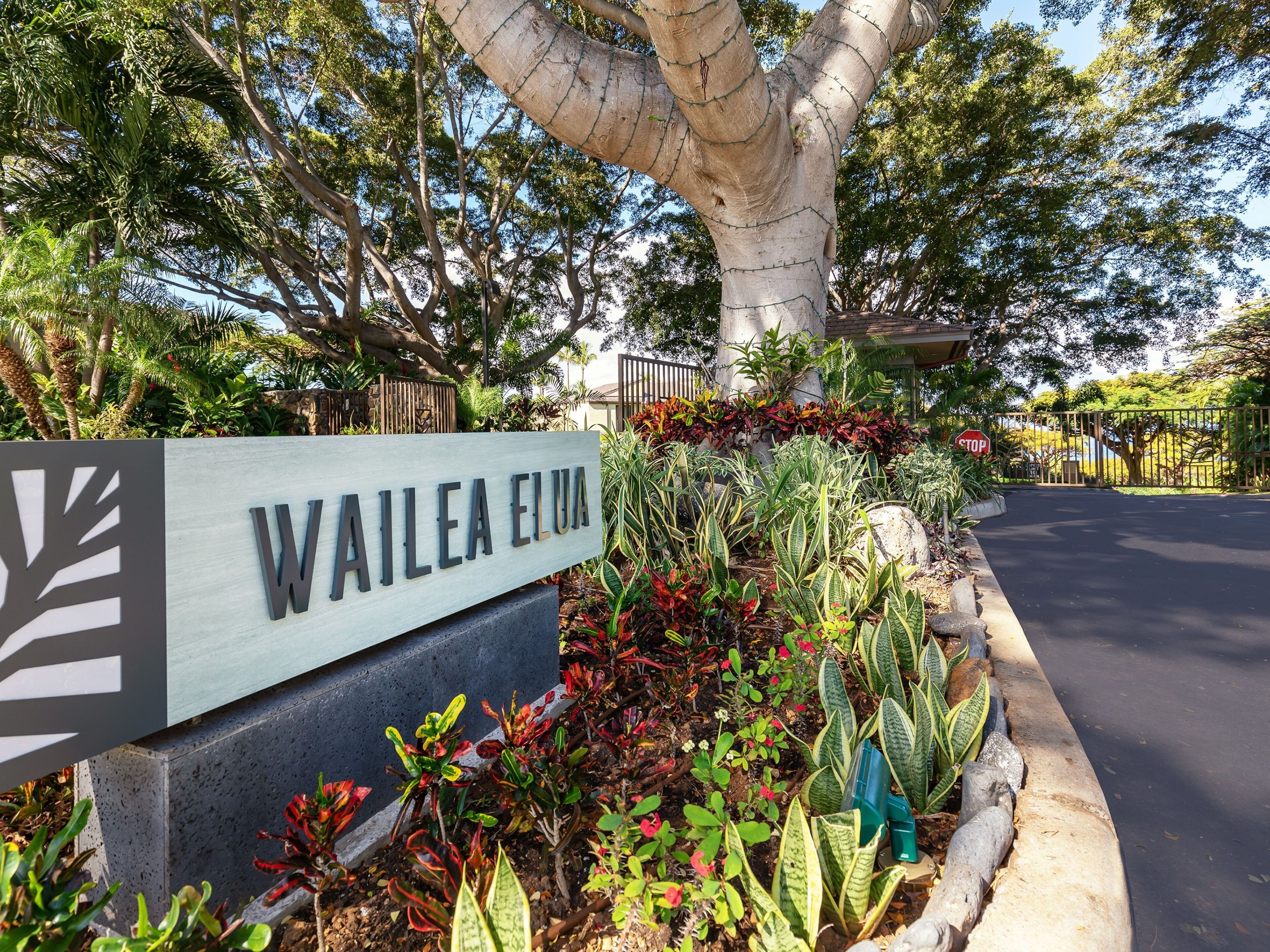 A sign for Wailoa Elua with a landscaped garden in front.