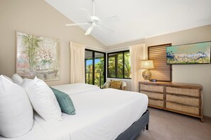Ein Schlafzimmer mit einem Bett, einem Deckenventilator, einem Fernseher, einem Fenster mit Vorhängen und einer Wanduhr.
