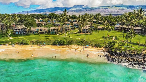 Een resort met meerdere gebouwen, een golfbaan en een strand.
