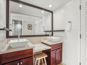 Une salle de bain moderne avec deux lavabos, un grand miroir et des meubles en bois.