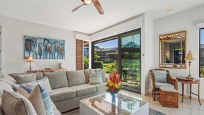 Ein modernes Wohnzimmer mit Sofa, Couchtisch und Deckenventilator.