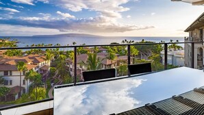 A balcony with a clear view of the ocean and a distant mountain.