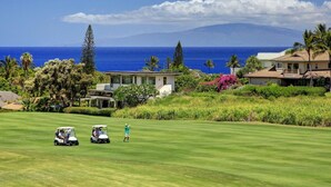 A golf course with a view of the ocean and a mountain in the distance. - Platinum Rated & Golf Course Views (Wailea)