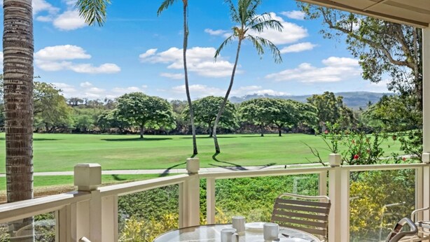 Un patio con mesa lista para comer, con vistas a un campo de golf.