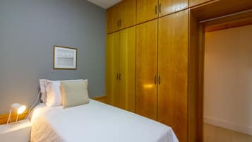 Tabla de planchar con plancha, internet y ropa de cama