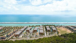 A resort with multiple buildings, a swimming pool, and a beach view. - Porto 2 Life - GAV Hotéis e Resorts (Ipojuca)