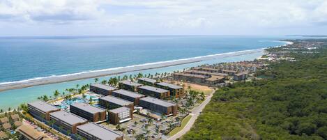 A resort with multiple buildings, a beach, and a pool area.