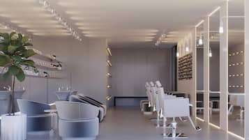 Een moderne, minimalistische hotellobby met zitgedeeltes, een receptiebalie en een wand waarop diverse faciliteiten staan afgebeeld.