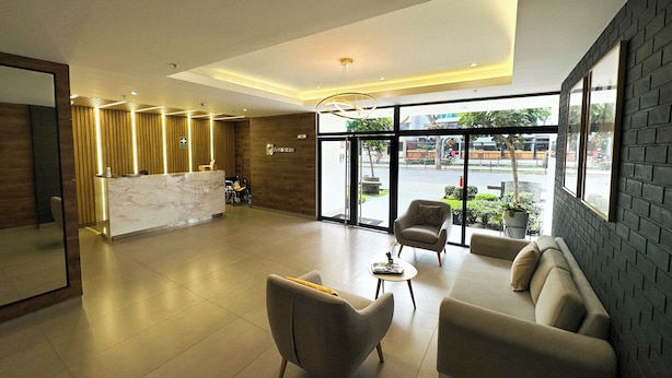 A spacious lobby with a reception desk, seating area, and large windows offering a view of the street. - Luxurious brand new Apt in the heart of miraflores (Lima)