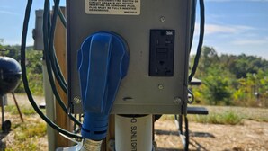 Un panneau solaire doté d’une prise bleue et d’une étiquette d’avertissement.