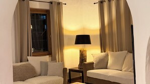 A cozy living room with a sofa, a coffee table, and a lamp. - Apartment in the old village, at the foot of the slopes. Residence le SQUAW VALLEY (Val-d'Isère)