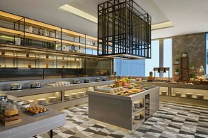 Una cocina moderna con varias encimeras, estantes con utensilios de cocina y una isla central con alimentos.