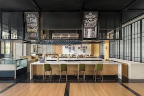 A modern bar area with a central island, bar stools, and a hanging sign that reads 'Be the reason someone smiles today.' - Four Points By Sheraton Leshan (Leshan)