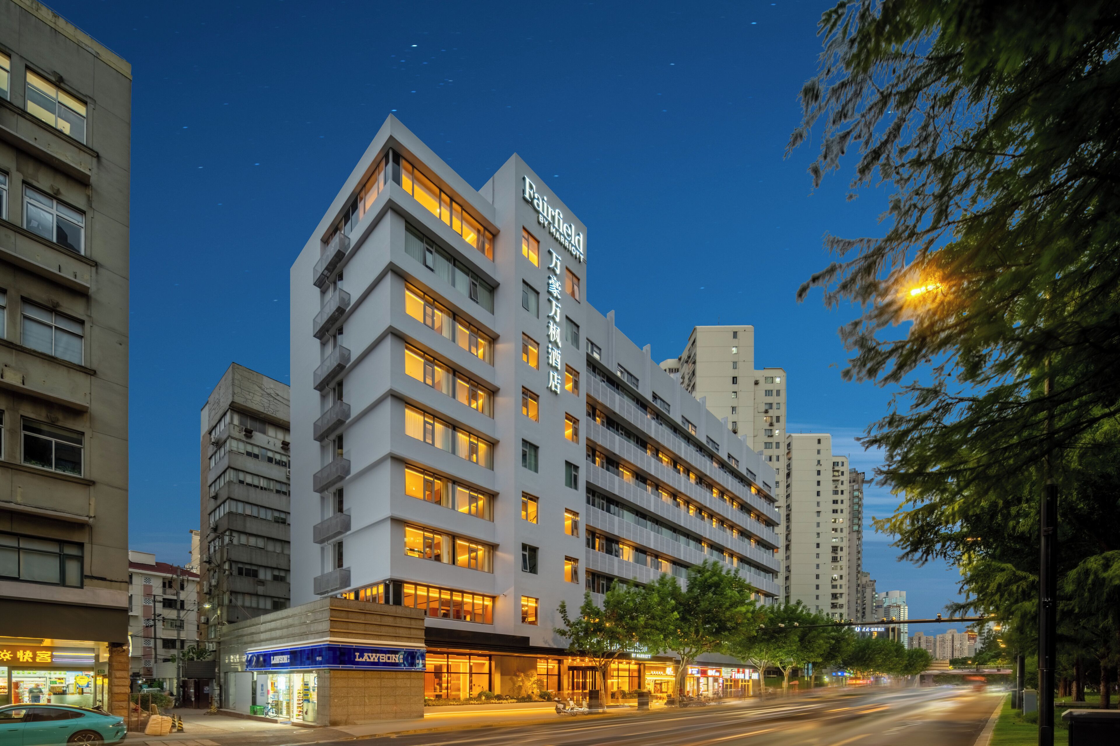 A multi-story hotel with a modern design, featuring a prominent sign at the top.