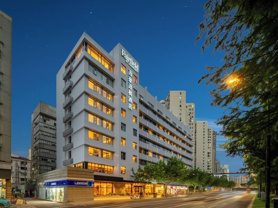A multi-story hotel with a modern design, featuring a prominent sign at the top.