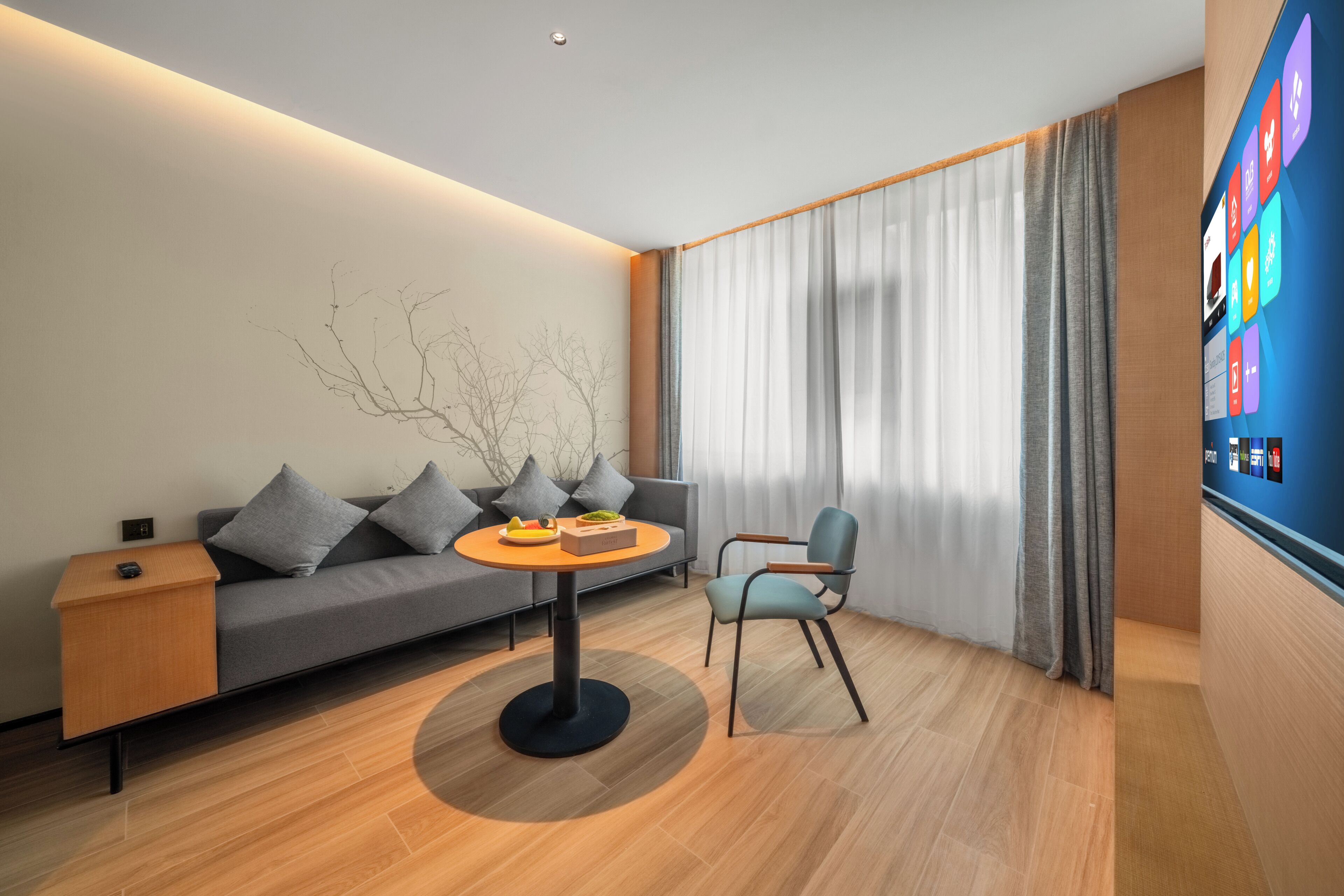 A modern living room with a sofa, a round table, and a chair.
