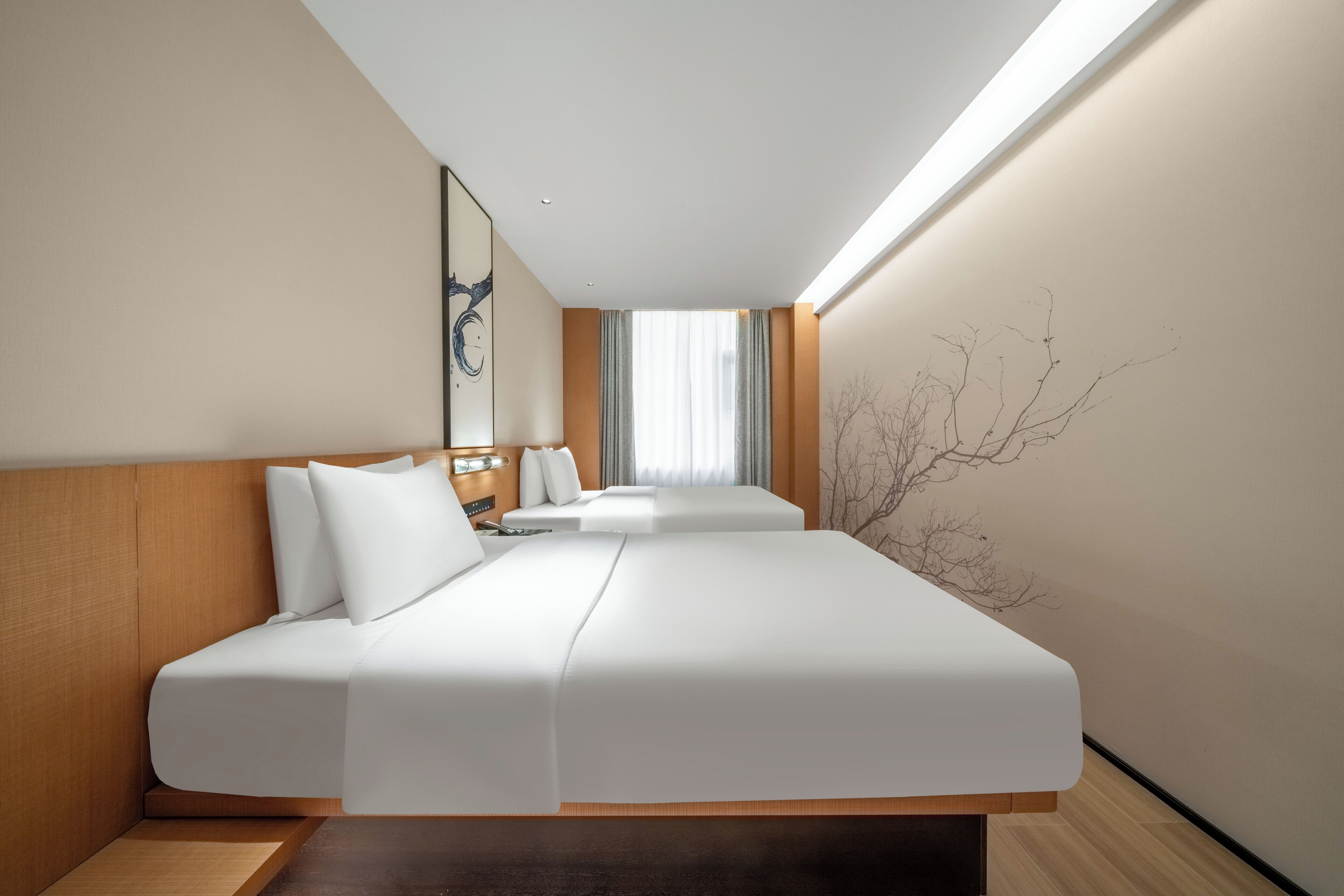 A modern hotel room with a large bed, a bedside table, and a view of the city.