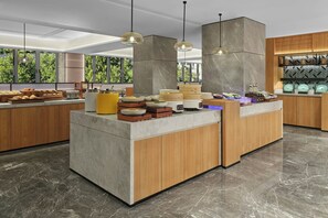 Una cocina moderna con una isla central, armarios de madera y piso de mármol.