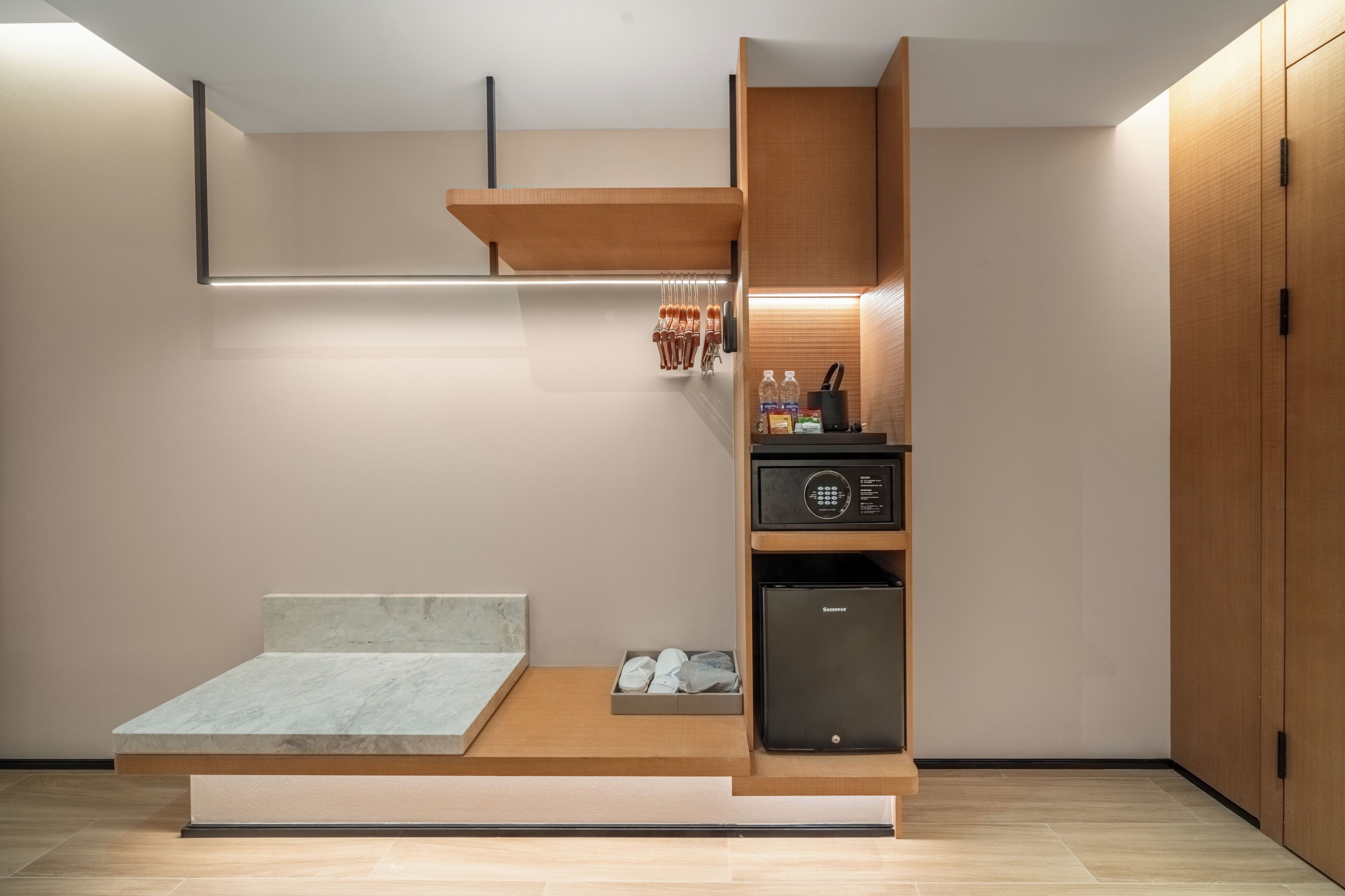 Quarto compacto e moderno, com cama embutida, pequeno espaço de cozinha e armário.