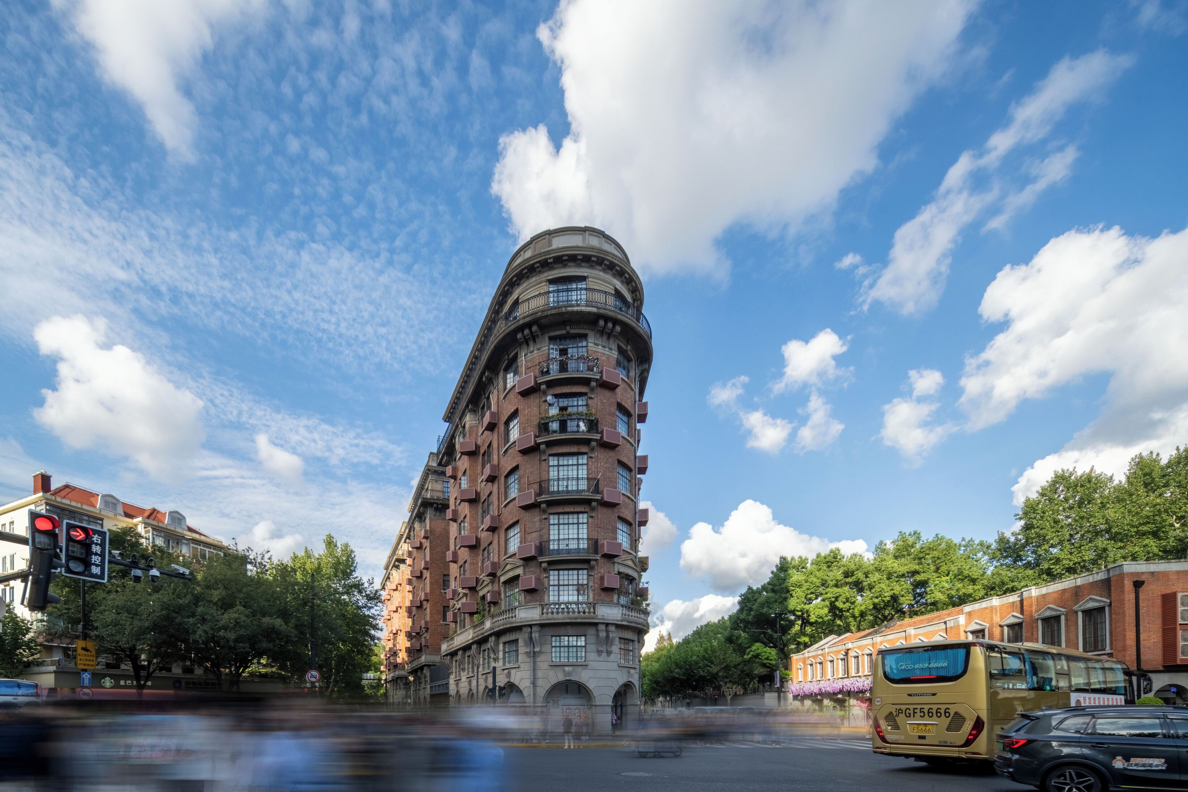 A multi-story building with a curved facade, large windows, and a central entrance.